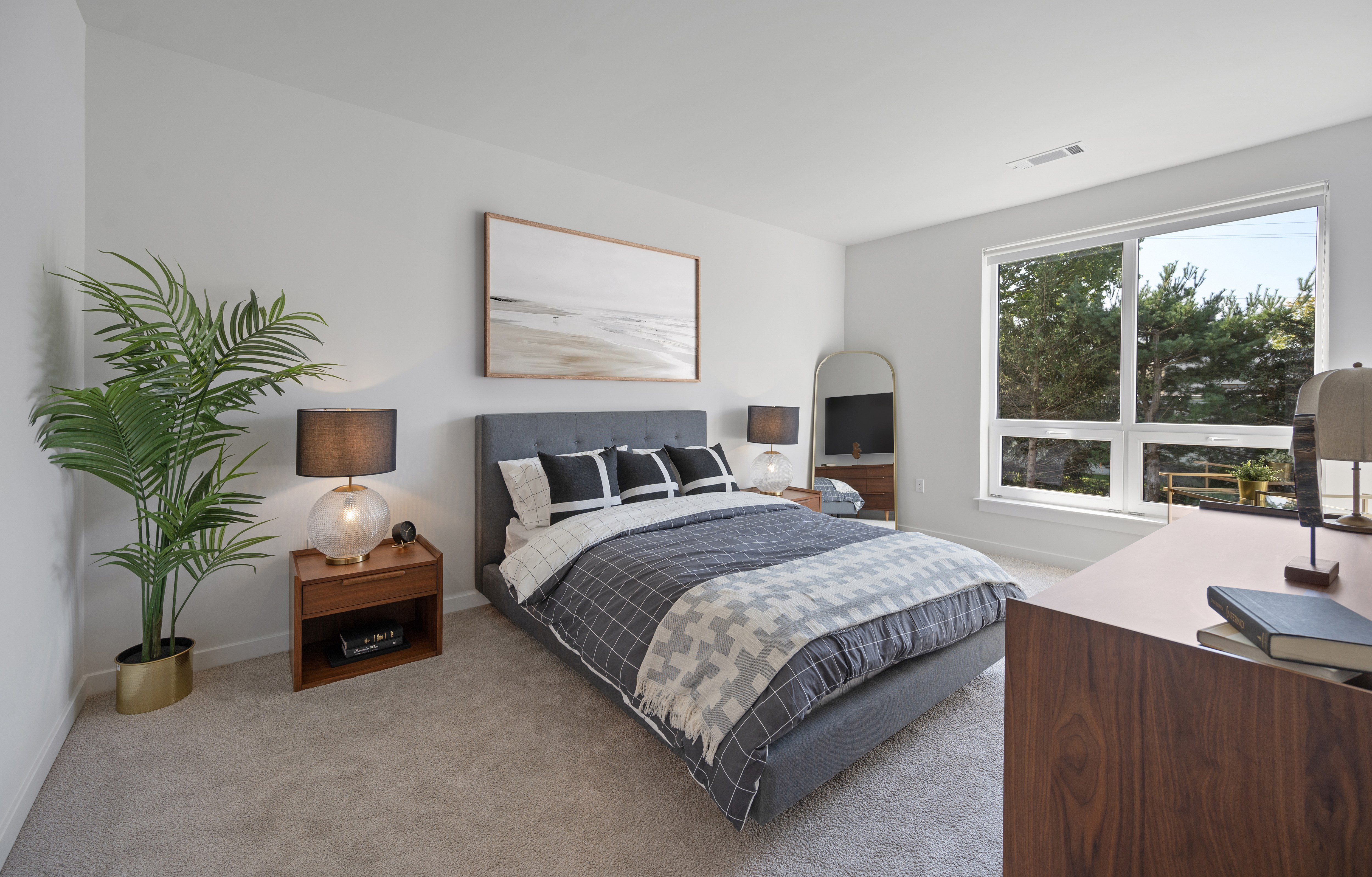 A bedroom with a large bed and a painting on the wall.
